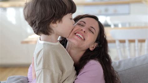 mother and son kiss|Joyful and cute young mom kiss son outdoors. Mother and kid。